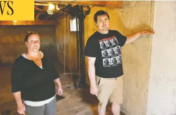  ?? GREG HALINDA / THE CANADIAN PRESS ?? Cora and Alec Dion show how high water rose in the basement of their home in Fort Mcmurray, Alta., when the city’s
downtown flooded recently. It was the second time they and their children were forced to flee their home.