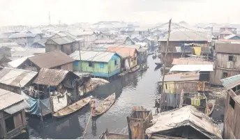  ?? — AFP photos ?? People in pirogues navigate their way in the slum community of Makoko in Lagos, Nigeria’s commercial capital.