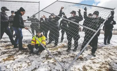  ?? JASON FRANSON / THE CANADIAN PRESS FILES ?? Supporters try to tear down the fence as police struggle with them outside GraceLife Church near Edmonton on
Sunday. The church has been fenced off by police and Alberta Health Services in violation of COVID-19 rules.