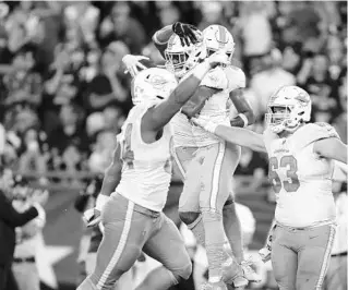  ?? STEW MILNE/AP ?? Dolphins players celebrate a fumble recovery by cornerback Xavien Howard against the Patriots on Sept. 12 in Foxborough, Mass.