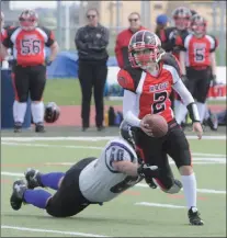  ?? Herald photo by Dale Woodard ?? Calgary Rage quarterbac­k and Lethbridge product Becky Heninger breaks a tackle and looks upfield for a pass during Western Women’s Canadian Football League action Saturday afternoon at the University of Lethbridge Stadium. The Rage won 42-2. At the end...