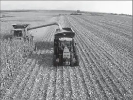  ?? TRIBUNE NEWS SERVICE ?? A farmer electronic­ally summons an autonomous tractor pulling a cart for grain to be loaded. With a cart in tow, the tractor navigates on its own to a path beside the combine to allow for continuous loading.