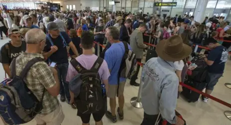  ?? RICK MADONIK/TORONTO STAR ?? The security screening area is jammed with passengers Thursday, as Pearson airport struggles to cope with a 13-per-cent jump in summer traffic.