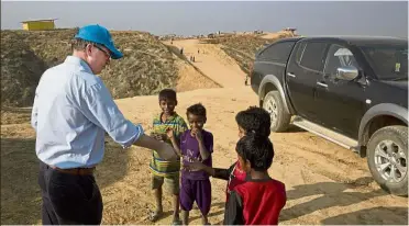  ?? — AP ?? Rare treat: Forsyth sharing biscuits with Rohingya refugee children during his visit to the Balukhali refugee camp near Cox’s Bazar, Bangladesh.