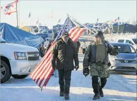  ?? Mark Boster Los Angeles Times ?? MILITARY VETERANS join members of the Standing Rock Sioux Tribe at the pipeline protest in Cannon Ball, N.D. Demonstrat­ors celebrated the decision.