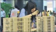  ?? PROVIDED TO CHINA DAILY ?? A Hangzhou denizen takes pictures of models of a housing estate at a sales center. China’s prominent property firms are entering the long-term home lease market, in line with government policy.