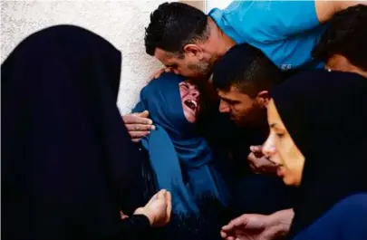  ?? FATIMA SHBAIR/ASSOCIATED PRESS ?? (left) mourned for Mohammed Abu Taima, who was killed in an Israeli airstrike Wednesday.