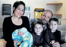  ?? LAURA BARTON/WELLAND TRIBUNE ?? Port Colborne couple Chelsea MacDonald and Adam White get cozy on the hospital bed as they welcome Rae-Ann Marie White to the family. Beside RaeAnn sits her five-year-old twin brothers Nova and Haven Walls.