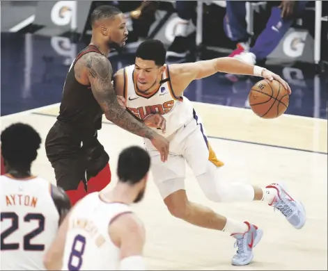  ?? ASSOCIATED PRESS ?? PHOENIX SUNS’ DEVIN BOOKER muscles his way toward the basket against Portland Trail Blazers’ Damien Lillard during the first half of a game on Monday in Phoenix.