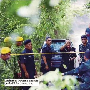  ??  ?? Mohamad bersama anggota polis di lokasi pencarian.