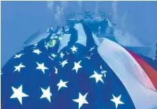  ?? FOTOS: DPA ?? USA- Flagge an der „ Vandenberg“: Es dauerte zwölf Jahre, bis man die Gelder zum Versenken des Schiffs beisammen hatte. Der zweieinhal­b Meter große Christus ( re.) ist mittlerwei­le von Feuerkoral­len überwucher­t.