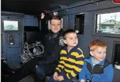  ?? TOM KELLY III – DIGITAL FIRST MEDIA ?? Kieran Walsh, 4, right, gets to take a ride in the SWAT vehicle. His brother, Seamus, and West Vincent Officer Nick Rubino are next to him.