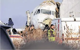  ?? Vladimir Tretyakov / Associated Press ?? Police stand guard Friday as rescuers work at the site of a crash involving a Bek Air jet with 98 people aboard near Almaty Internatio­nal Airport in Kazakhstan.