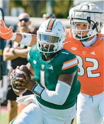  ?? AL DIAZ/MIAMI HERALD ?? Miami quarterbac­k Cam Ward scrambles out of the pocket as Hurricanes linebacker Raul Aguirre Jr. gives chase during Saturday’s spring football game at Cobb Stadium in Coral Gables.