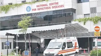  ?? — AFP file photo ?? An ambulance leaves the National Centre for Infectious Diseases, where patients suffering from the Covid-19 novel coronaviru­s are being cared for, in Singapore.