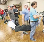  ?? PHOTOS BY CURTIS COMPTON / CCOMPTON@AJC.COM ?? Men line up for the gun range following the Community Bible Church monthly men’s study group at the American Heritage Gun Range in McDonough.