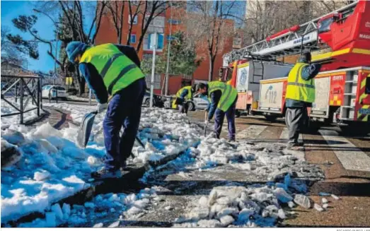  ?? RICARDO RUBIO / EP ?? Varios operarios limpiaban ayer la nieve del alcantaril­lado del Camino de Hormiguera­s antes de que comiencen las lluvias en Madrid.