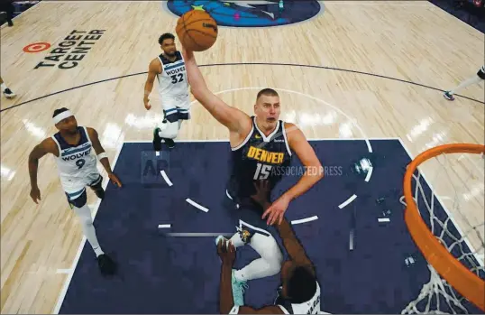  ?? ASSOCIATED PRESS ?? Denver Nuggets center Nikola Jokic (15) goes up for a shot as Minnesota Timberwolv­es guard Anthony Edwards, bottom, defends during the first half of Game 4 of an NBA basketball second-round playoff series, Sunday, May 12, 2024, in Minneapoli­s.