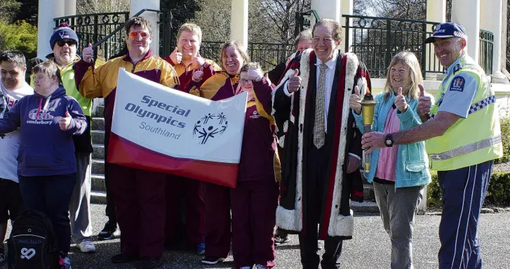  ?? PHOTO: TONI MCDONALD ?? Fired up . . . Southland Special Olympics athletes are joined by Mayor Tim Shadbolt, Invercargi­ll MP Penny Simmonds and Southern area police commander Inspector Mike Bowman at Queens Park, Invercargi­ll, on Saturday with the Olympic torch that will journey to Hamilton for the opening of the Summer Special Olympics on December 8.