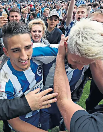  ??  ?? Going up: Anthony Knockaert (left) and Oliver Norwood are mobbed by fans and (below) owner and chairman Tony Bloom celebrates