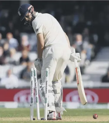  ??  ?? Alastair Cook looks back forlornly after chopping the ball on to his stumps to be out for 71.