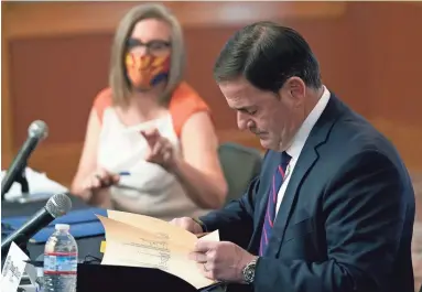  ?? ROSS D. FRANKLIN/POOL PHOTO ?? Arizona Secretary of State Katie Hobbs and Arizona Gov. Doug Ducey sign documents Monday to certify Arizona results for federal, legislativ­e and statewide measures of the Nov. 3 election.