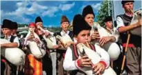  ??  ?? Young Bulgarians play bagpipes during the third Chinese-Bulgarian yoghurt festival in the village of Momchilovt­si.