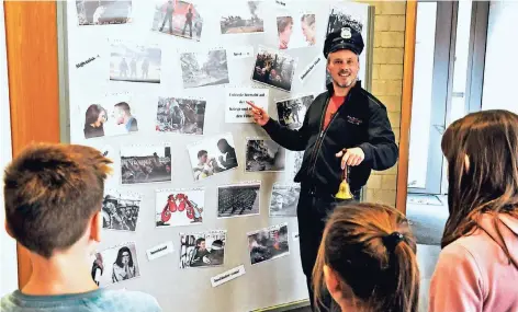  ?? FOTO: BISCHÖFLIC­HE PRESSESTEL­LE / CHRISTIAN BREUER ?? „Jeder kennt Hass und Gewalt“sagt Schulseels­orger Markus van Berlo als „Einsatzlei­ter“und zeigt den Kindern Beispiele an einer Fotowand. Anschließe­nd gehen die Kinder auf die Suche nach Friedensme­nschen.