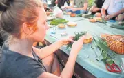  ??  ?? A tourist learns how to make krathong in Santi Chaiprakan Park.