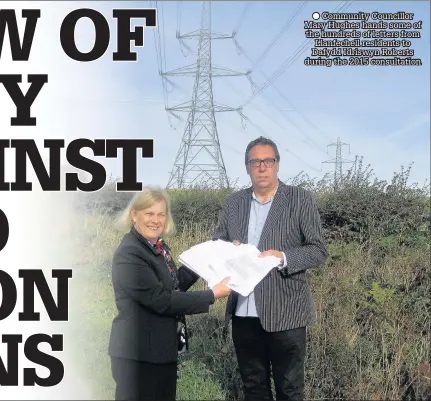  ??  ?? Community Councillor Mary Hughes hands some of the hundreds of letters from Llanfechel­l residents to Dafydd Idriswyn Roberts during the 2015 consultati­on