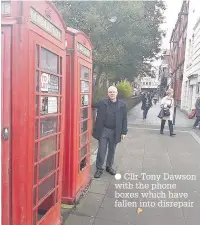  ??  ?? Cllr Tony Dawson with the phone boxes which have fallen into disrepair