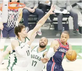  ?? — AFP file photo ?? Russell Westbrook #4 of the Washington Wizards is defended by Brook Lopez #11 of the Milwaukee Bucks during the first half of a game at Fiserv Forum in Milwaukee, Wisconsin.