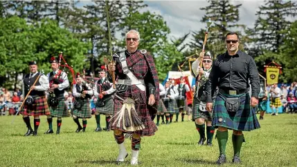  ?? DAVID BAIRD PHOTOGRAPH­Y ?? Sword bearer Bruce Nell and chieftain Patrick Hellier march in front of the City of Christchur­ch Pipe Band at Saturday’s Hororata Highland Games.