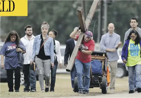  ?? ERIC GAY / THE ASSOCIATED PRESS ?? Stephen Hope carries a cross Sunday following a service for the victims of the Sutherland Springs, Texas, church shooting. “Rather than choose darkness as that young man did that day, we choose life,” said Pastor Frank Pomeroy.