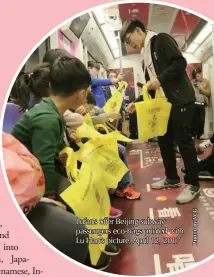  ??  ?? Lufans offer Beijing subway passengers eco-bags printed with Lu Han’s picture, April 12, 2017