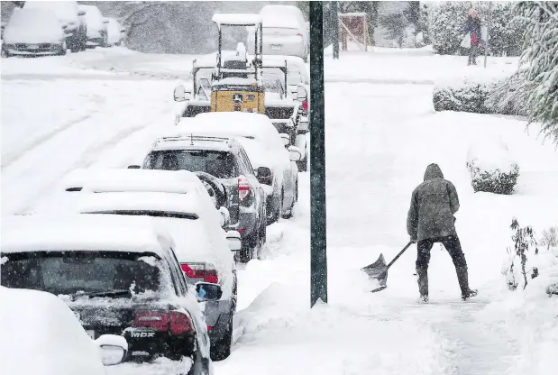  ?? — NICK PROCAYLO ?? Homeowners clear sidewalks on Tuesday morning in Vancouver. February snowfall is already more than triple the usual amount.