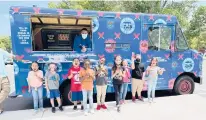  ??  ?? Children enjoy ice cream from the Ice Cream for a Dream truck.