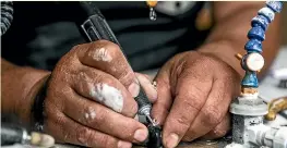  ?? ?? Timoti Moran at work carving dot pendants for children in state care.