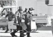  ?? AP PHOTO ?? Firefighte­rs at the morgue in Ain Amenas, Algeria, carry a coffin containing a person killed during the gas facility hostage situation.