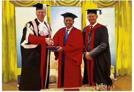  ??  ?? (From left) Prof Day presenting the honorary degree to Dr Zaini while NUMed provost and chief executive officer Prof Roger Barton looks on.