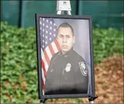  ??  ?? A photo of DeKalb County Officer Edgar Isidro Flores, who died in the line of duty in December, is displayed at DeKalb County police headquarte­rs in Tucker.