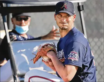  ?? CURTIS COMPTON/CURTIS.COMPTON@AJC.COM ?? Braves manager Brian Snitker (left) watches Charlie Morton during a Friday morning pitching session at Cooltoday Park in North Port, Florida. Snitker, 65, is in his 45th season with the organizati­on.