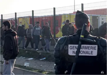  ??  ?? Photo ci-dessus :
En octobre 2016, des forces de l’ordre surveillen­t l’évacuation de la
« Jungle », nom donné aux camps de migrants et de réfugiés installés à partir du début des années 2000 aux abords de l’entrée française du tunnel sous la Manche et de la zone portuaire de Calais. En 2016, 33 filières de passeurs ont été démantelée­s. Malgré ce travail intense des enquêteurs, aucune victime de la traite n’a été identifiée et protégée dans cette zone cette année-là. (© Edward Crawfort/ Shuttersto­ck)