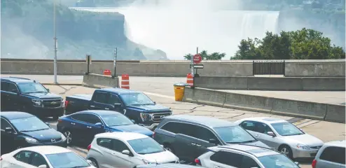  ?? GEOFF ROBINS / AFP VIA GETTY IMAGES ?? People wait at the Rainbow Bridge in Niagara Falls on Monday as Canada reopens its borders for non-essential travel
to fully vaccinated Americans. American visitors cheered the reopening of the world’s longest land boundary.