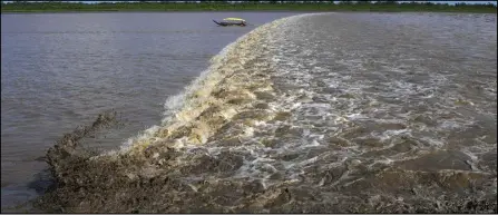  ?? ASSOCIATED PRESS ?? A boat sails in front of a wave caused by the advance of sea water on the river during the dry season, Sept. 12, in the Bailique Archipelag­o, district of Macapa, state of Amapa, northern Brazil. During a full moon, the sea invades the river with such strength that, in some places, it turns into a single giant wave of up to 13 feet, a phenomenon known as pororoca.