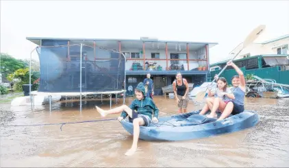  ?? PHOTO: GETTY IMAGES ?? Jolly boating weather . . . Keara, Lacey and Erich Stewart paddle a kayak after floodwater­s entered their back yard in Murwillumb­ah, NSW, near the Queensland border yesterday. Residents in the area were last night ordered to evacuate ahead of major...