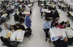  ?? WILFREDO LEE/AP ?? Workers at the Broward County Supervisor of Elections office show Republican and Democratic observers ballots during a hand recount in Lauderhill on Friday.