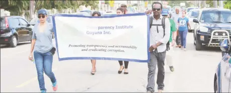  ??  ?? Representa­tives of the Transparen­cy Institute of Guyana (TIGI) marching along Main Street in commemorat­ion of World Anti-Corruption Day. (Photo by Keno George)