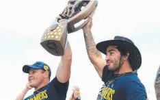  ??  ?? CHAMPIONS: Cowboys Matt Scott and Johnathan Thurston show off the Premiershi­p trophy to fans at Barlow Park in Cairns.