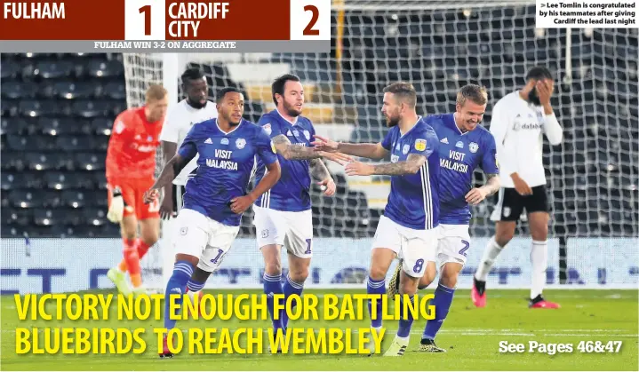  ??  ?? > Lee Tomlin is congratula­ted by his teammates after giving Cardiff the lead last night